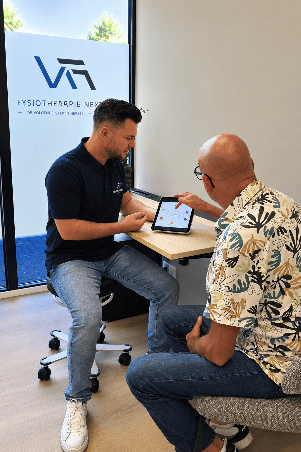 Leefstijlcoach bespreekt met een client de resultaten op een tablet