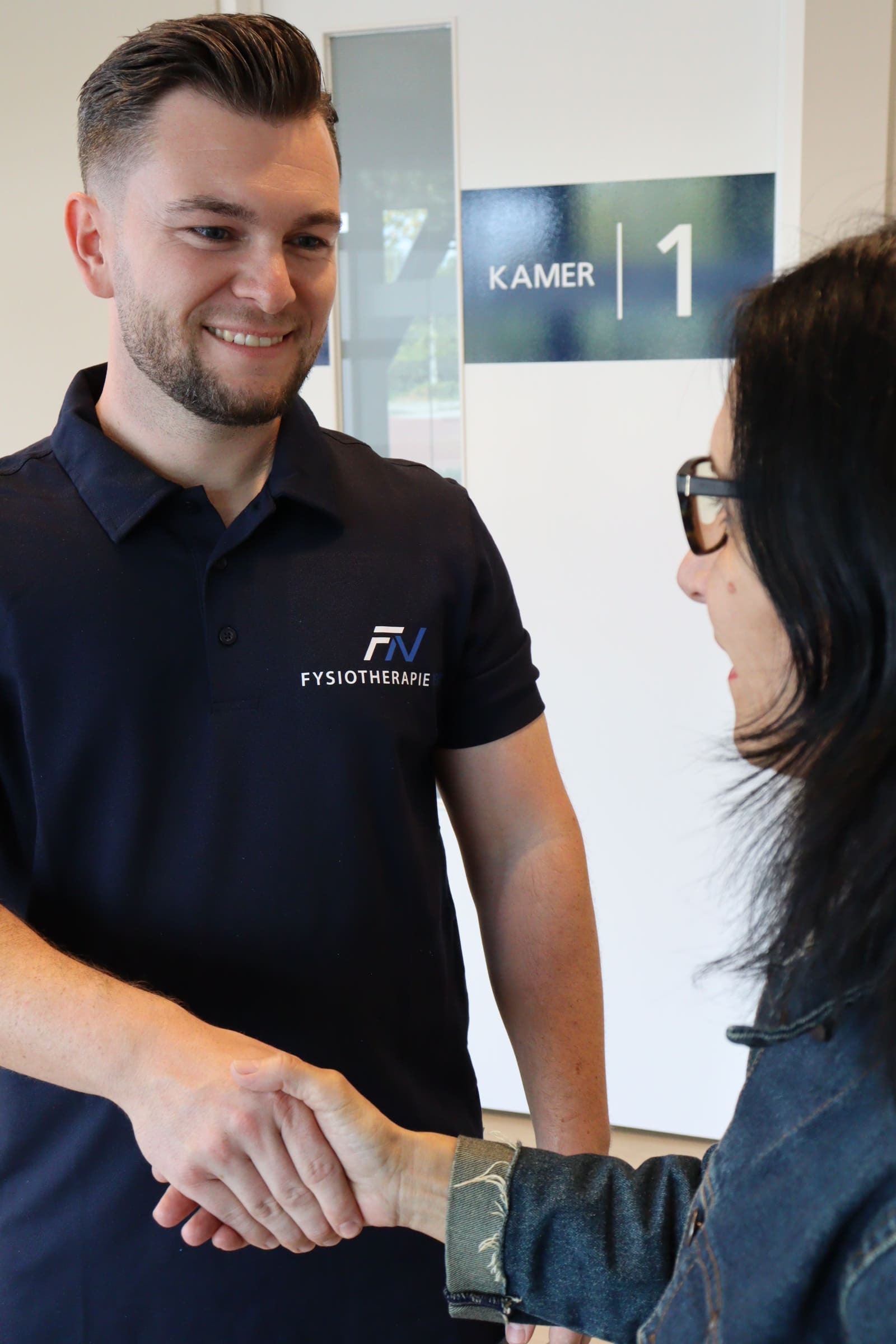 Fysiotherapeut begroet een client met een handdruk