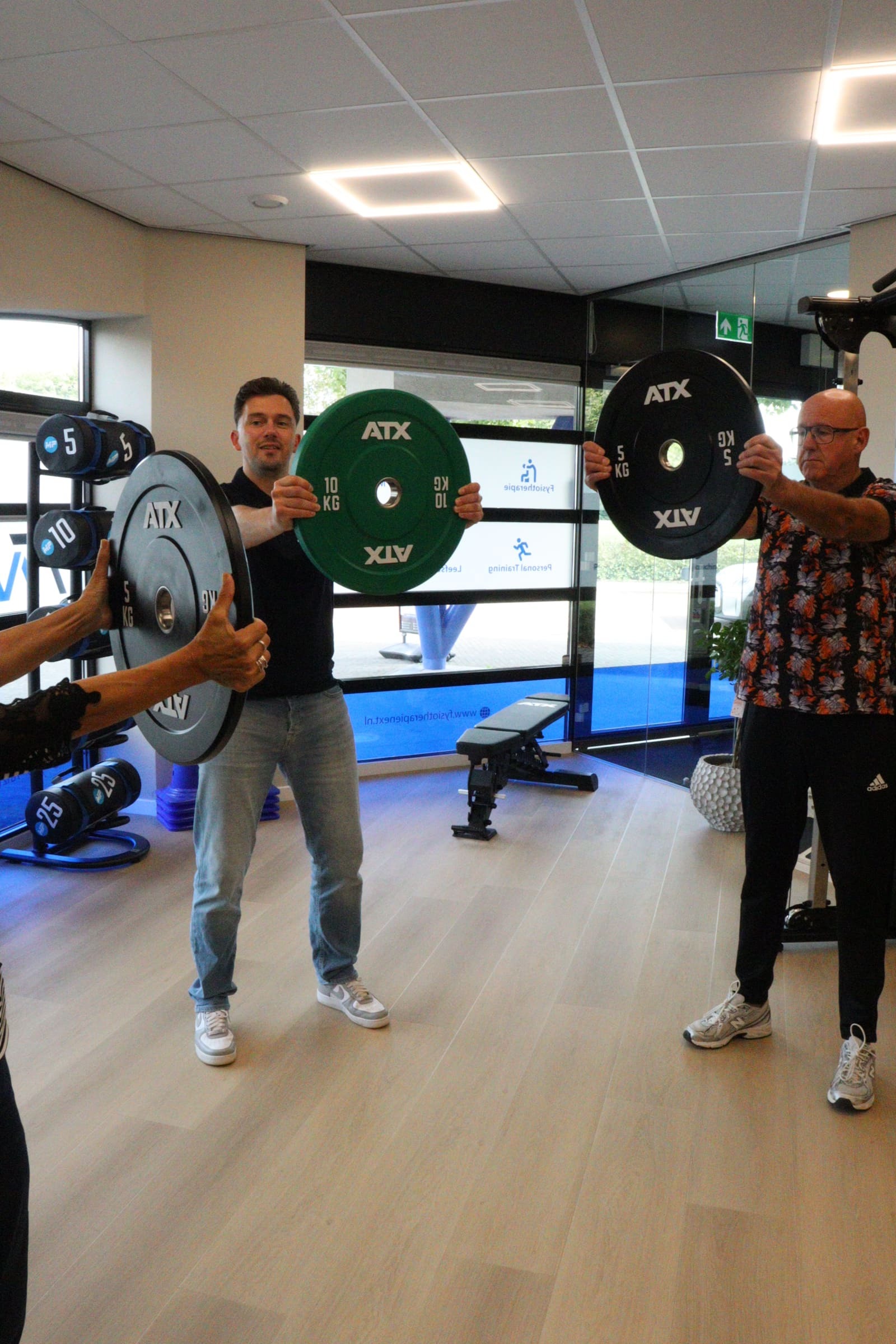 Groep traint samen met halterschijven in de oefenzaal